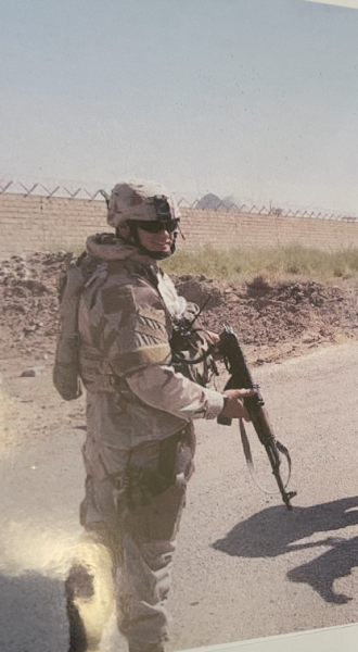 man in military uniform holds a rifle